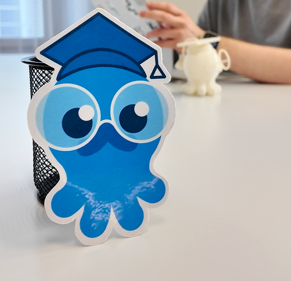 blue octopus, new face of the AI Buddy with Vinzent in the background on his iPad}